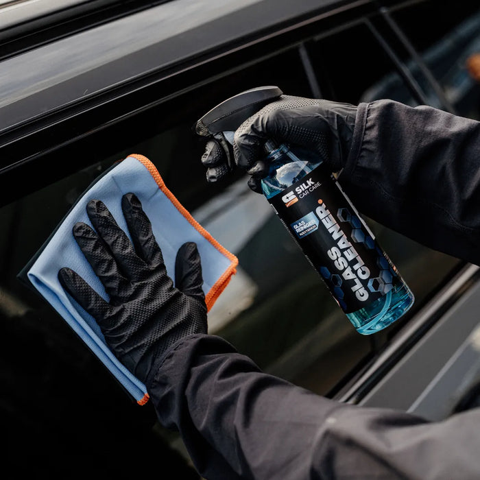 Reinigung von Autoscheiben mit Glasreiniger und Mikrofasertuch für streifenfreien Glanz