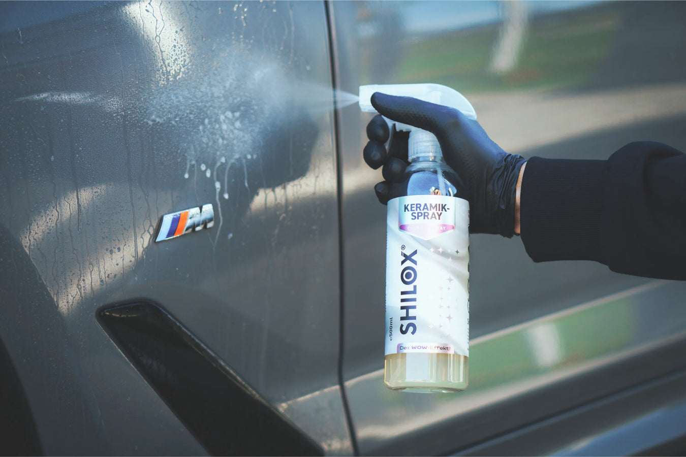 Hand trägt Keramik Spray auf den Autolack auf für Versiegelung und schnellen Wachsschutz